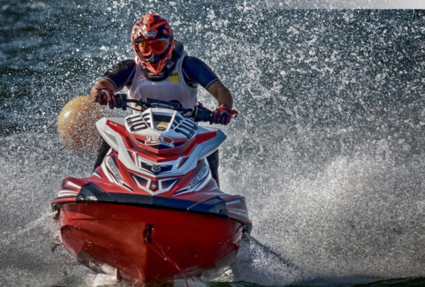 A person rides a jet ski throwing water spray during a race, HD Desktop Wallpaper
