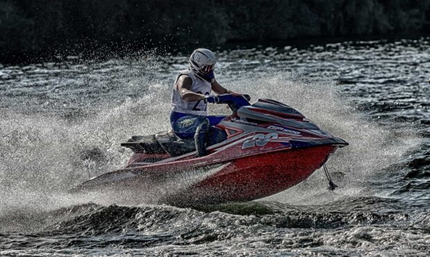 A jet ski rider is making splashes while racing on rough water, HD Desktop Wallpaper