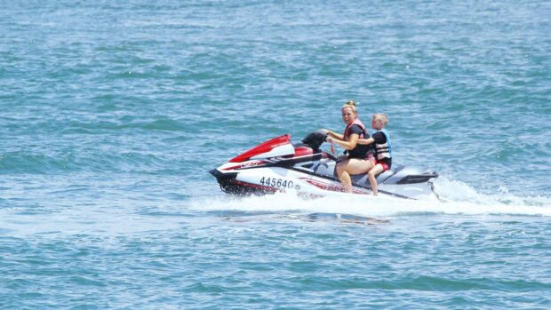 A woman and a child are enjoying jet ski riding on the calm sea, HD Desktop Wallpaper