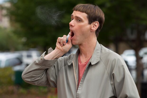 Jim Carrey applying lip balm on a street with a background of trees and vehicles, HD Desktop Wallpaper