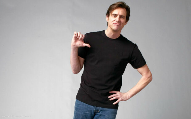 Jim Carrey stands with a playful thumb gesture and a smirk, HD Desktop Wallpaper