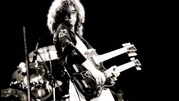 Jimmy Page playing a double neck guitar during a live performance on stage