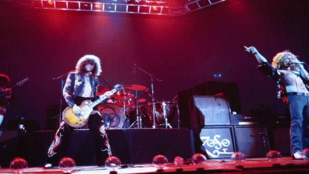 Jimmy Page playing guitar on stage during a live concert performance