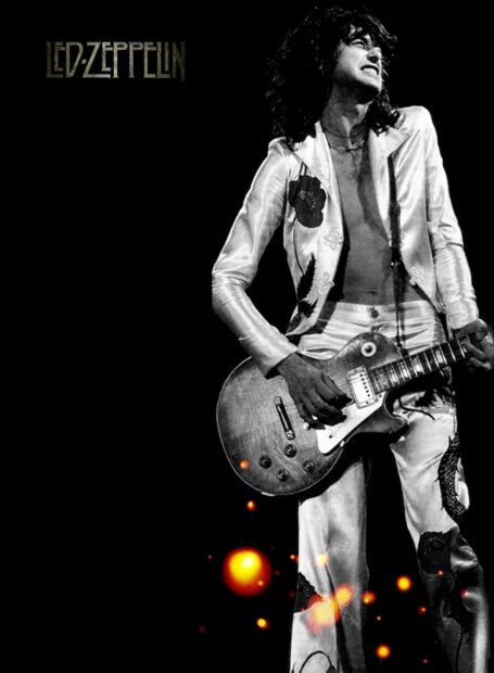Jimmy Page playing guitar on stage wearing a white suit with Led Zeppelin logo in the background
