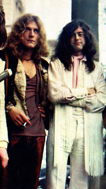 Jimmy Page standing next to a bandmate wearing vintage 1970s clothing