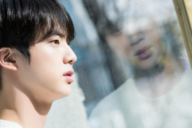 Jin BTS looks thoughtfully at his reflection on a window pane, HD Desktop Wallpaper