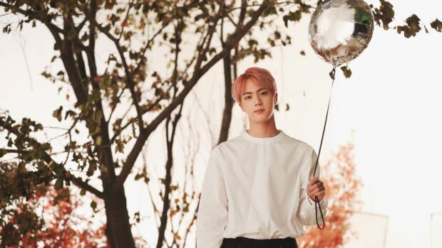 Jin BTS holding a silver balloon outdoors in a scenic autumn setting, HD Desktop Wallpaper