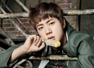 Young man with short brown hair eating ice cream in an urban setting.
