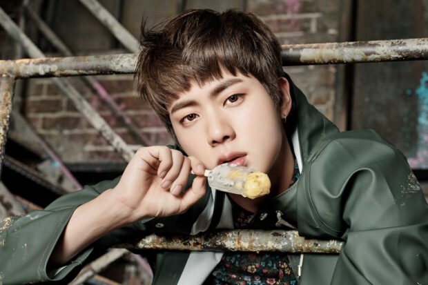 A close up of Jin from BTS enjoying ice cream near rusty metal bars, HD Desktop Wallpaper
