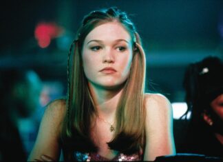 Aging woman at nightclub with long brown hair and sequin top.
