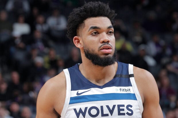 Karl Anthony Towns focused on the basketball court wearing a Wolves jersey