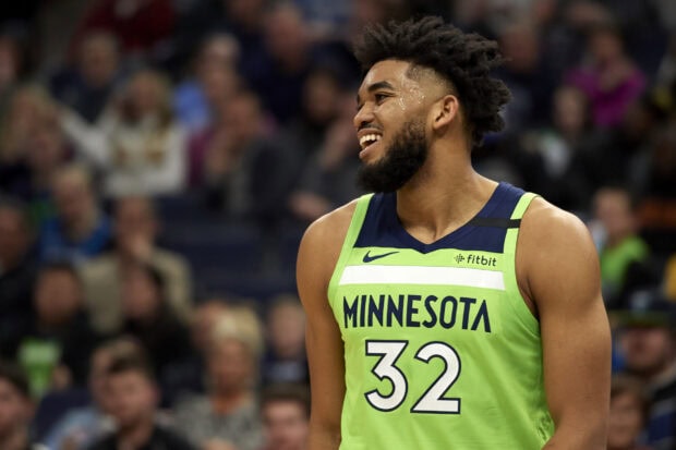 Karl Anthony Towns wearing a Minnesota basketball jersey smiling during the game