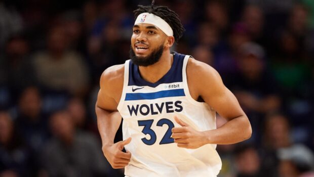 Karl Anthony Towns playing basketball wearing a Wolves jersey running on court