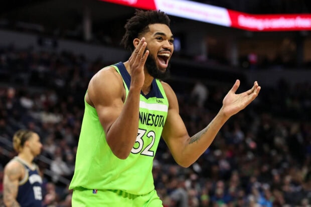Karl Anthony Towns expressing excitement during a basketball game wearing a Minnesota jersey