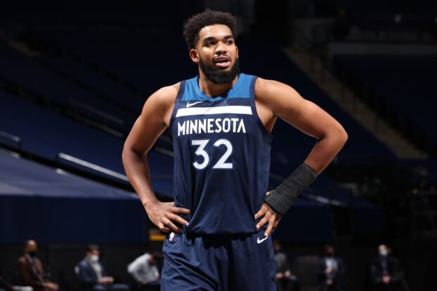 Karl Anthony Towns stands with hands on hips during a Minnesota basketball game