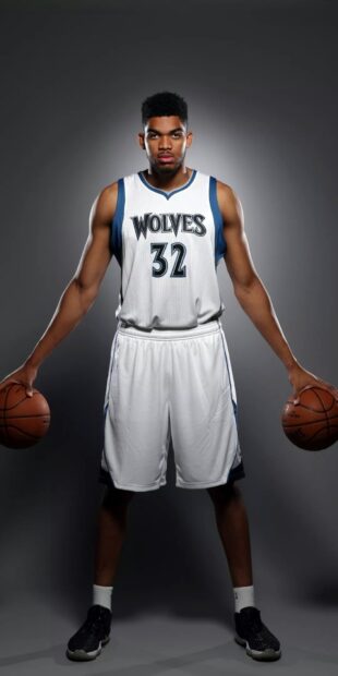Karl Anthony Towns in a Wolves jersey holding two basketballs on each hand standing confidently
