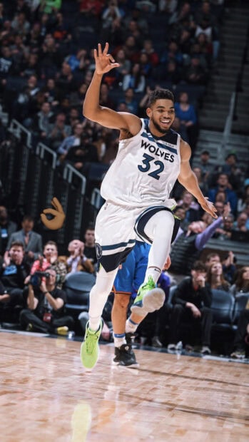 Karl Anthony Towns jumping in action wearing a Wolves jersey celebrating on the basketball court