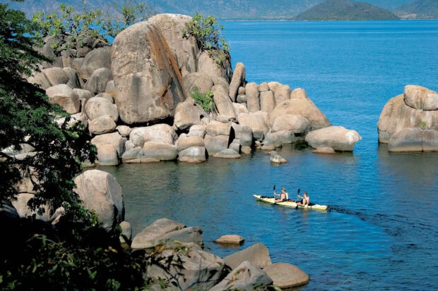 Two people kayaking near large rocks on lake Malawi, 2K Desktop Wallpaper