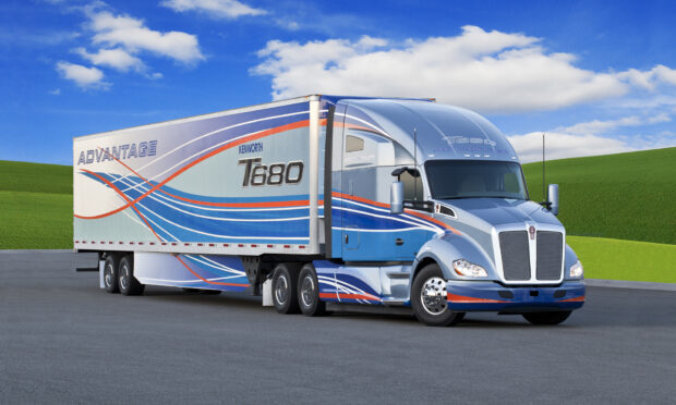 A Kenworth T680 truck with blue and orange stripes parked on a road with green hills and a cloudy sky, HD Desktop Wallpaper