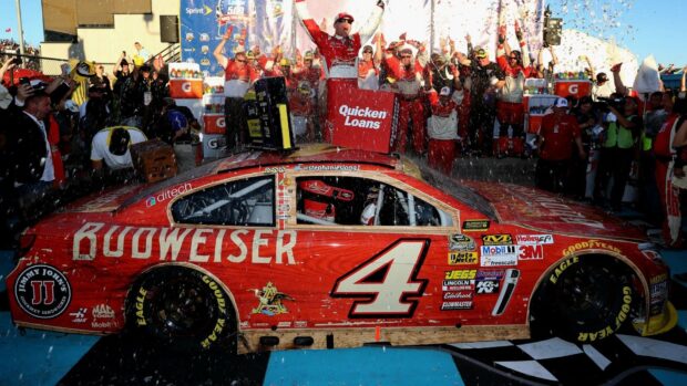 Kevin Harvick celebrating on top of his race car with team and confetti falling, HD Desktop Wallpaper