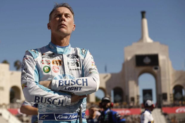 Kevin Harvick is standing with arms crossed wearing a racing suit at a race event, HD Desktop Wallpaper