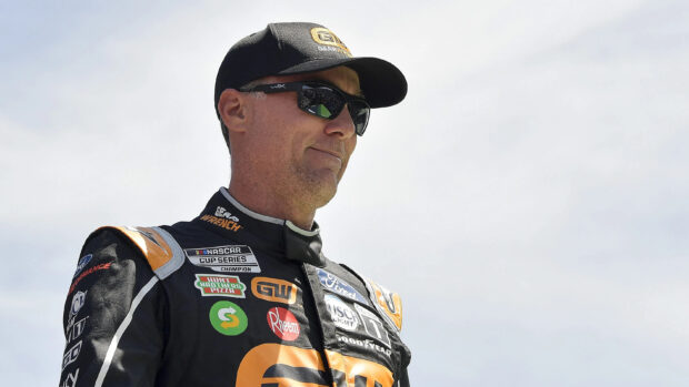 Kevin Harvick is wearing a racing suit and sunglasses while standing outdoors on a clear day, 2K Desktop Wallpaper