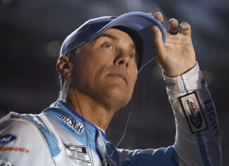 Kevin Harvick adjusts his cap while wearing a racing suit during a NASCAR event, HD Desktop Wallpaper