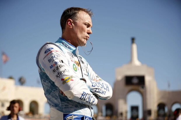 Kevin Harvick stands in his racing suit with arms crossed and earphones under clear sky, HD Desktop Wallpaper