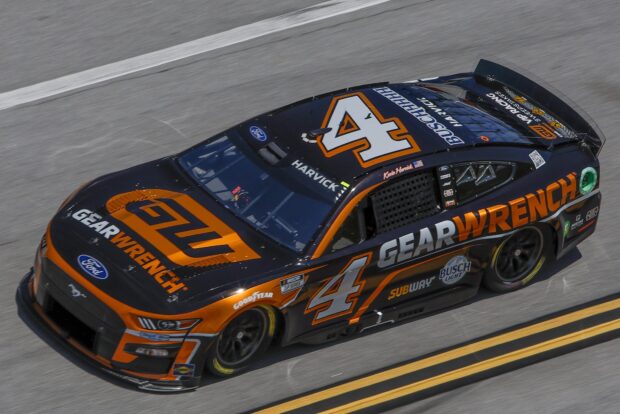 A black and orange Kevin Harvick car drives fast on the racetrack during a race, HD Desktop Wallpaper