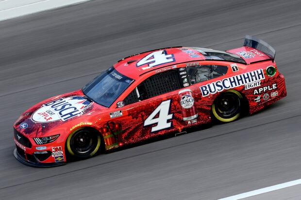 A red race car driven by Kevin Harvick speeds along the racetrack during a NASCAR event, 2K Desktop Wallpaper