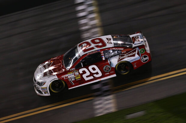 A race car driven by Kevin Harvick is captured moving fast on a race track at night, 2K Desktop Wallpaper