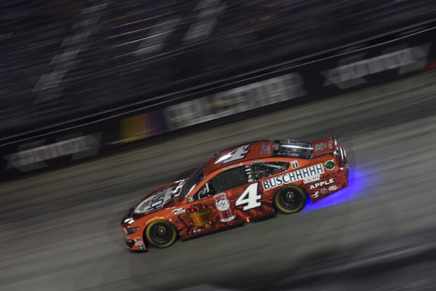A Kevin Harvick car races at high speed on the track during a night race, 2K Desktop Wallpaper