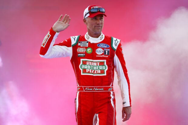 Kevin Harvick waving in his racing suit with a pink smoky background, 2K Desktop Wallpaper