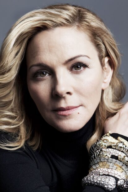 A close up portrait of Kim Cattrall wearing a black turtleneck and decorative bracelets, 2K Phone Wallpaper