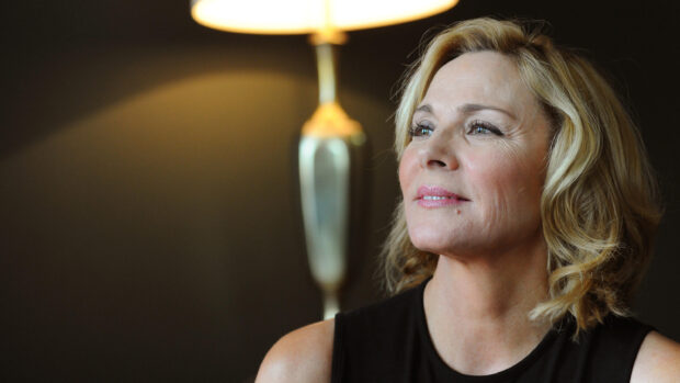 Kim Cattrall looking thoughtfully in a soft lit room, 2K Desktop Wallpaper
