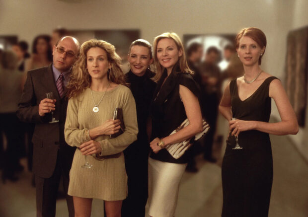 Kim Cattrall stands with friends dressed elegantly at a social gathering, HD Desktop Wallpaper