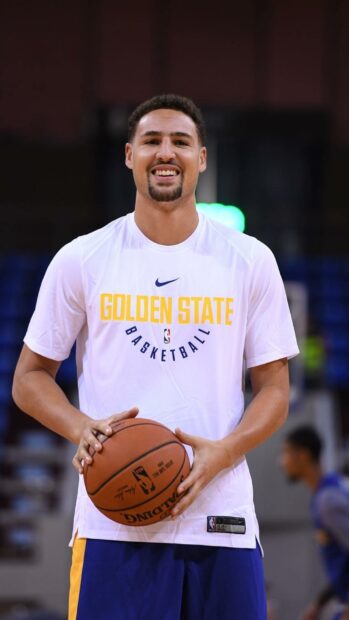 Klay Thompson holding a basketball and smiling during a practice session, HD Mobile Wallpaper