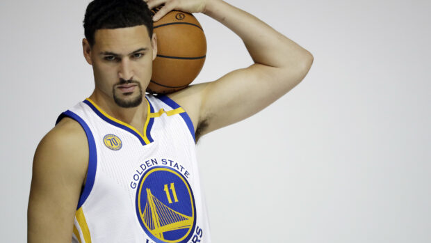 Klay Thompson confidently holding a basketball over his shoulder in a Golden State Warriors jersey, 2K Desktop Wallpaper