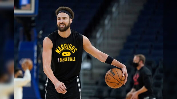 Klay Thompson is holding a basketball on the court during practice, HD Desktop Wallpaper