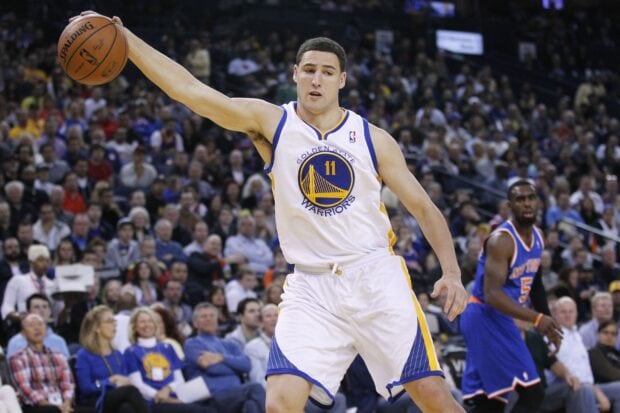 Klay Thompson is seen passing the basketball during a packed game, HD Desktop Wallpaper