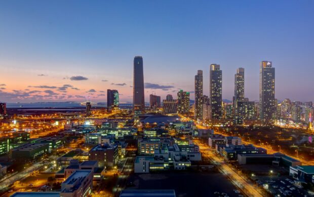 A panoramic view of Korea city skyline at dusk with tall buildings and vibrant lights