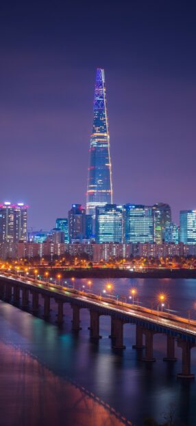 Night view of Korea cityscape with Lotte Tower and illuminated bridge over river