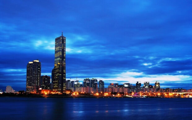 Night cityscape view of Korea skyline with tall buildings and blue sky
