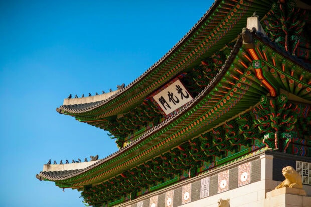 Traditional Korean architectural details under clear blue sky in Korea