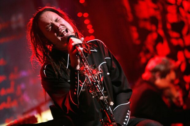 The Korn lead singer passionately performing on stage with a decorated microphone stand
