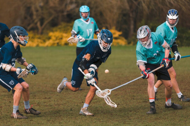 A lacrosse game with players in protective gear competing on a field, HD Desktop Wallpaper