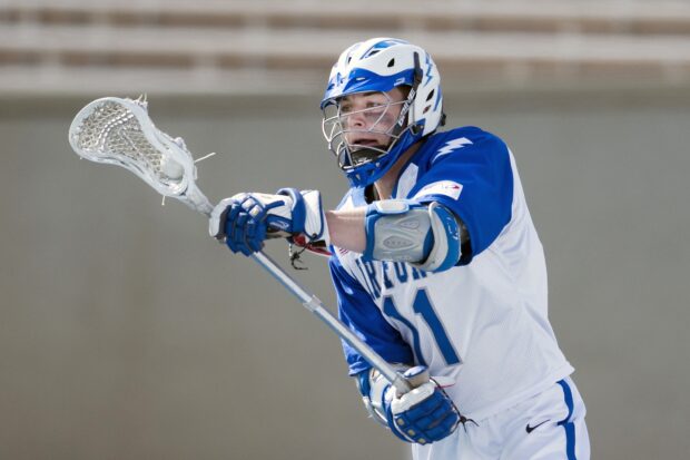 A lacrosse player wearing blue and white gear prepares to throw the ball during a game, HD Desktop Wallpaper