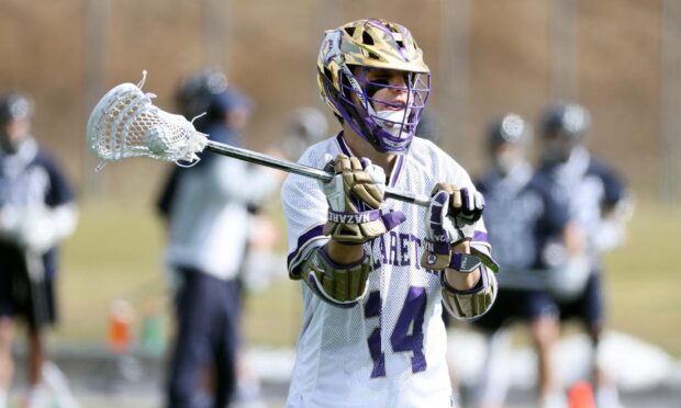 A lacrosse player wearing a helmet and gloves holds the stick during a game, HD Desktop Wallpaper
