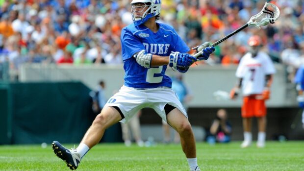 A lacrosse player wearing blue uniform is preparing to throw the ball during a game, HD Desktop Wallpaper