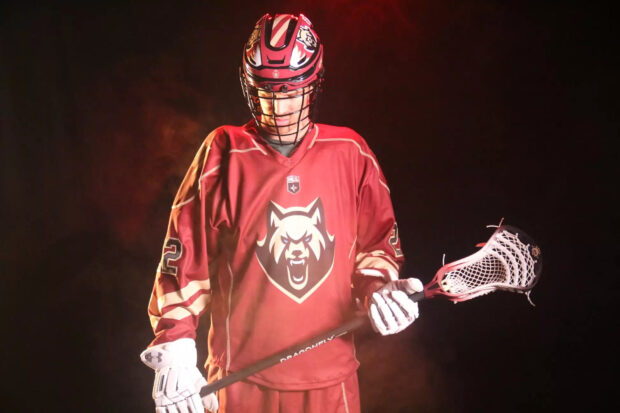 A lacrosse player wearing a red uniform and holding a lacrosse stick, HD Desktop Wallpaper